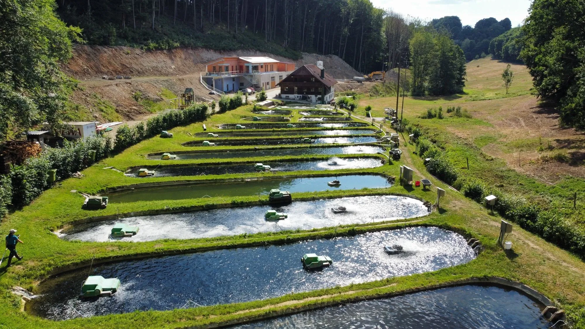 Luftbild der Teiche der Fischzucht Grasse mit Belüftern, eingebettet in das Tal.